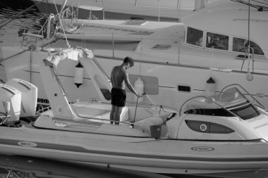 İtalya, Sicilya, Akdeniz, Marina di Ragusa (Ragusa Eyaleti); 23 Temmuz 2025, limandaki büyük bir lastik teknede adam - EDITORIAL