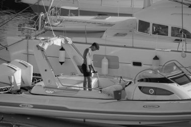 İtalya, Sicilya, Akdeniz, Marina di Ragusa (Ragusa Eyaleti); 23 Temmuz 2025, limandaki büyük bir lastik teknede adam - EDITORIAL