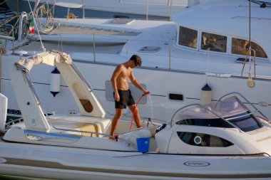 İtalya, Sicilya, Akdeniz, Marina di Ragusa (Ragusa Eyaleti); 23 Temmuz 2025, limandaki büyük bir lastik teknede adam - EDITORIAL