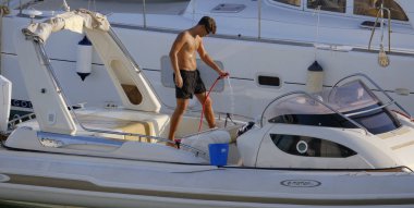 İtalya, Sicilya, Akdeniz, Marina di Ragusa (Ragusa Eyaleti); 23 Temmuz 2025, limandaki büyük bir lastik teknede adam - EDITORIAL