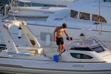 İtalya, Sicilya, Akdeniz, Marina di Ragusa (Ragusa Eyaleti); 23 Temmuz 2025, limandaki büyük bir lastik teknede adam - EDITORIAL