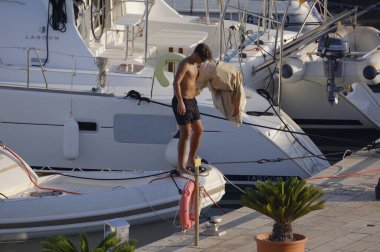 İtalya, Sicilya, Akdeniz, Marina di Ragusa (Ragusa Eyaleti); 23 Temmuz 2025, limandaki büyük bir lastik teknede adam - EDITORIAL