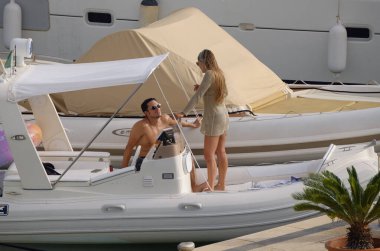 İtalya, Sicilya, Akdeniz, Marina di Ragusa (Ragusa ili); 26 Temmuz 2025, limanda bir kauçuk teknede çift - EDITORIAL