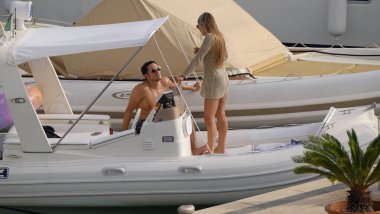 İtalya, Sicilya, Akdeniz, Marina di Ragusa (Ragusa ili); 26 Temmuz 2025, limanda bir kauçuk teknede çift - EDITORIAL