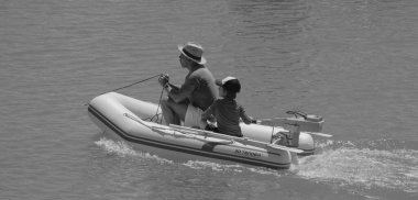 İtalya, Sicilya, Akdeniz, Marina di Ragusa (Ragusa Eyaleti); 1 Ağustos 2025, limanda küçük bir kauçuk teknede çift