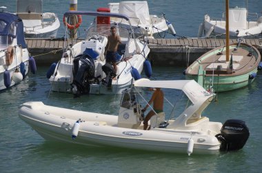 İtalya, Sicilya, Akdeniz, Marina di Ragusa (Ragusa ili); 3 Ağustos 2025, limandaki motorlu teknelerde erkekler - EDITORIAL
