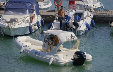 İtalya, Sicilya, Akdeniz, Marina di Ragusa (Ragusa ili); 3 Ağustos 2025, limandaki motorlu teknelerde erkekler - EDITORIAL