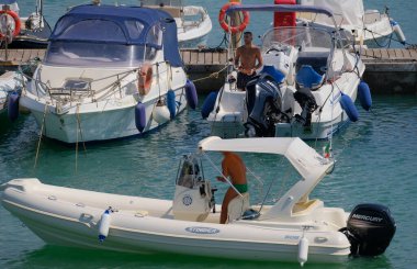 İtalya, Sicilya, Akdeniz, Marina di Ragusa (Ragusa ili); 3 Ağustos 2025, limandaki motorlu teknelerde erkekler - EDITORIAL