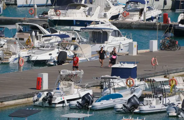 İtalya, Sicilya, Akdeniz, Marina di Ragusa (Ragusa ili); 4 Ağustos 2025, limandaki insanlar, motorlu tekneler ve lüks yatlar - EDITORIAL