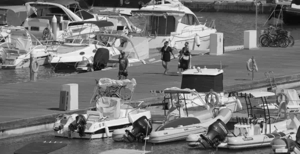 İtalya, Sicilya, Akdeniz, Marina di Ragusa (Ragusa ili); 4 Ağustos 2025, limandaki insanlar, motorlu tekneler ve lüks yatlar - EDITORIAL