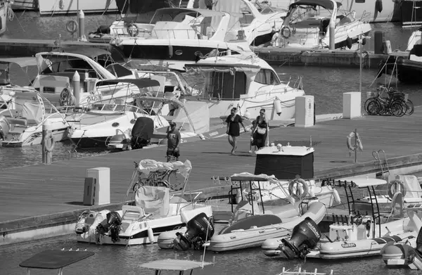 İtalya, Sicilya, Akdeniz, Marina di Ragusa (Ragusa ili); 4 Ağustos 2025, limandaki insanlar, motorlu tekneler ve lüks yatlar - EDITORIAL