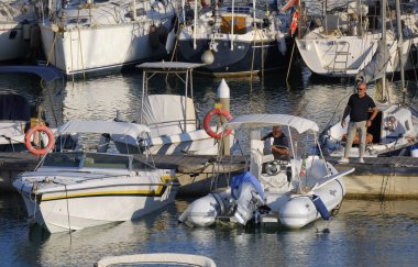 İtalya, Sicilya, Akdeniz, Marina di Ragusa (Ragusa ili); 6 Ağustos 2025, limandaki insanlar, motorlu tekneler ve lüks yatlar - EDITORIAL