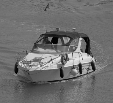 İtalya, Sicilya, Akdeniz, Marina di Ragusa (Ragusa Eyaleti); 7 Ağustos 2025, limanda lüks bir yatta bir adam - EDITORIAL