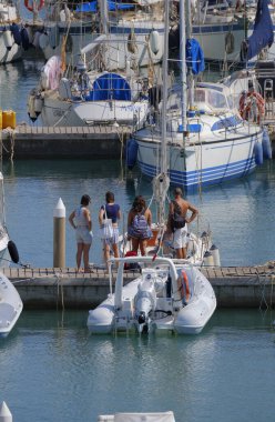 İtalya, Sicilya, Akdeniz, Marina di Ragusa (Ragusa ili); 8 Ağustos 2025, limandaki insanlar, motorlu tekneler ve lüks yatlar - EDITORIAL