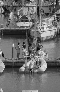 İtalya, Sicilya, Akdeniz, Marina di Ragusa (Ragusa ili); 8 Ağustos 2025, limandaki insanlar, motorlu tekneler ve lüks yatlar - EDITORIAL