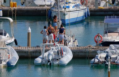 İtalya, Sicilya, Akdeniz, Marina di Ragusa (Ragusa ili); 8 Ağustos 2025, limandaki insanlar, motorlu tekneler ve lüks yatlar - EDITORIAL