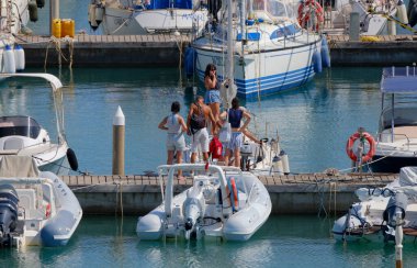 İtalya, Sicilya, Akdeniz, Marina di Ragusa (Ragusa ili); 8 Ağustos 2025, limandaki insanlar, motorlu tekneler ve lüks yatlar - EDITORIAL