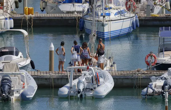 İtalya, Sicilya, Akdeniz, Marina di Ragusa (Ragusa ili); 8 Ağustos 2025, limandaki insanlar, motorlu tekneler ve lüks yatlar - EDITORIAL