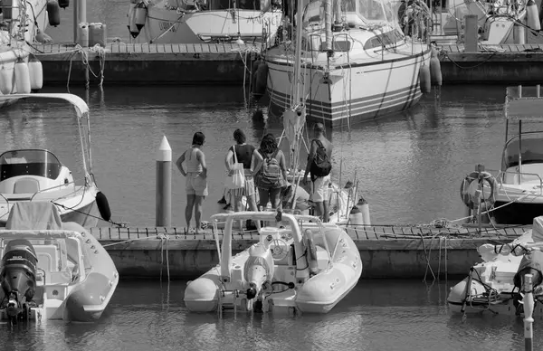 İtalya, Sicilya, Akdeniz, Marina di Ragusa (Ragusa ili); 8 Ağustos 2025, limandaki insanlar, motorlu tekneler ve lüks yatlar - EDITORIAL