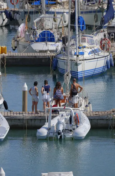 İtalya, Sicilya, Akdeniz, Marina di Ragusa (Ragusa ili); 8 Ağustos 2025, limandaki insanlar, motorlu tekneler ve lüks yatlar - EDITORIAL