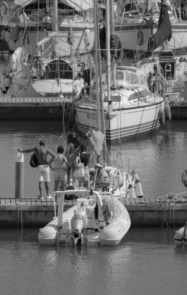 İtalya, Sicilya, Akdeniz, Marina di Ragusa (Ragusa ili); 8 Ağustos 2025, limandaki insanlar, motorlu tekneler ve lüks yatlar - EDITORIAL