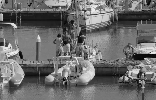 İtalya, Sicilya, Akdeniz, Marina di Ragusa (Ragusa ili); 8 Ağustos 2025, limandaki insanlar, motorlu tekneler ve lüks yatlar - EDITORIAL