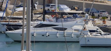 İtalya, Sicilya, Akdeniz, Marina di Ragusa (Ragusa ili); 9 Ağustos 2025, limanda lüks bir yatta çift - EDITORIAL