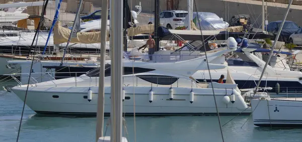 İtalya, Sicilya, Akdeniz, Marina di Ragusa (Ragusa ili); 9 Ağustos 2025, limanda lüks bir yatta çift - EDITORIAL