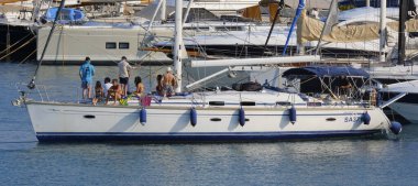 İtalya, Sicilya, Akdeniz, Marina di Ragusa (Ragusa ili); 9 Ağustos 2025, limandaki bir yelkenli teknesinde insanlar - EDITORIAL