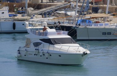 İtalya, Sicilya, Akdeniz, Marina di Ragusa (Ragusa Eyaleti); 11 Ağustos 2025, limanda lüks bir yatta adam - EDITORIAL