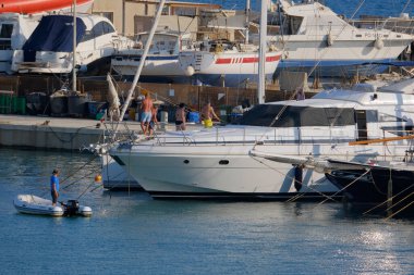 İtalya, Sicilya, Akdeniz, Marina di Ragusa (Ragusa Eyaleti); 12 Ağustos 2025, limanda lüks bir yatta insanlar - EDITORIAL