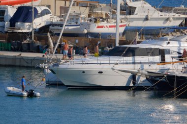 İtalya, Sicilya, Akdeniz, Marina di Ragusa (Ragusa Eyaleti); 12 Ağustos 2025, limanda lüks bir yatta insanlar - EDITORIAL