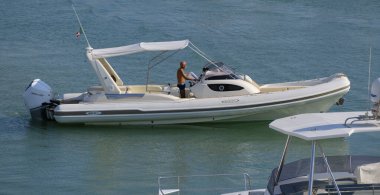 İtalya, Sicilya, Akdeniz, Marina di Ragusa (Ragusa ili); 13 Ağustos 2025, limanda büyük bir kauçuk teknede adam - EDITORIAL