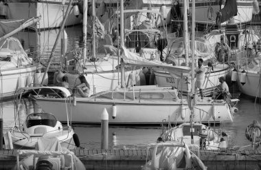 İtalya, Sicilya, Akdeniz, Marina di Ragusa (Ragusa ili); 21 Ağustos 2025, limandaki bir yelkenli teknesinde insanlar - EDITORIAL