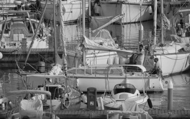 İtalya, Sicilya, Akdeniz, Marina di Ragusa (Ragusa ili); 21 Ağustos 2025, limandaki bir yelkenli teknesinde insanlar - EDITORIAL