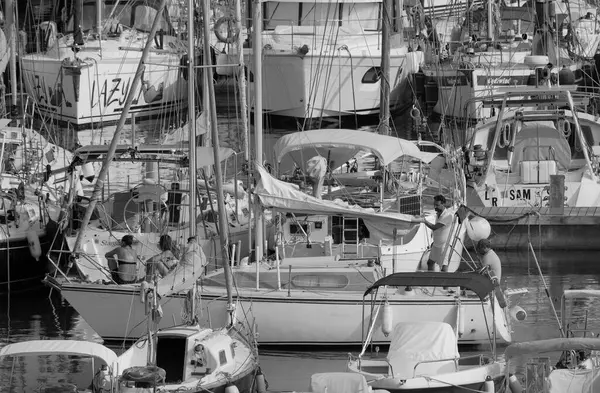 İtalya, Sicilya, Akdeniz, Marina di Ragusa (Ragusa ili); 21 Ağustos 2025, limandaki bir yelkenli teknesinde insanlar - EDITORIAL