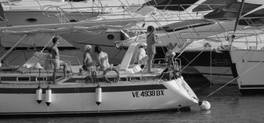 İtalya, Sicilya, Akdeniz, Marina di Ragusa (Ragusa Eyaleti); 22 Ağustos 2025, limandaki bir yelkenli ve lüks yatlarda yaşayan insanlar - EDITORIAL