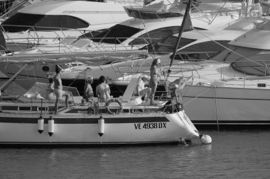 İtalya, Sicilya, Akdeniz, Marina di Ragusa (Ragusa Eyaleti); 22 Ağustos 2025, limandaki bir yelkenli ve lüks yatlarda yaşayan insanlar - EDITORIAL