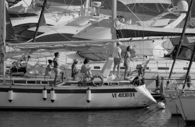 İtalya, Sicilya, Akdeniz, Marina di Ragusa (Ragusa Eyaleti); 22 Ağustos 2025, limandaki bir yelkenli ve lüks yatlarda yaşayan insanlar - EDITORIAL