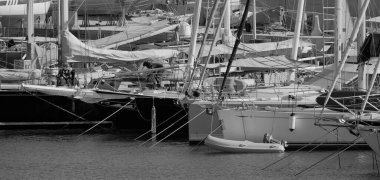 İtalya, Sicilya, Akdeniz, Marina di Ragusa (Ragusa Eyaleti); 24 Ağustos 2025, limandaki bir yelkenli ve lüks yatlarda adam - EDITORIAL