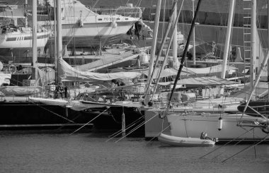 İtalya, Sicilya, Akdeniz, Marina di Ragusa (Ragusa Eyaleti); 24 Ağustos 2025, limandaki bir yelkenli ve lüks yatlarda adam - EDITORIAL