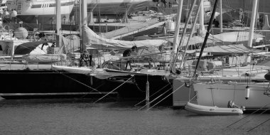 İtalya, Sicilya, Akdeniz, Marina di Ragusa (Ragusa Eyaleti); 24 Ağustos 2025, limandaki bir yelkenli ve lüks yatlarda adam - EDITORIAL