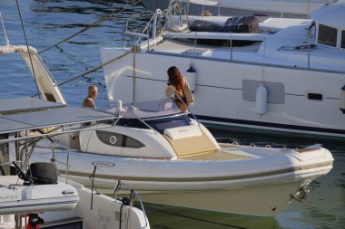 İtalya, Sicilya, Akdeniz, Marina di Ragusa (Ragusa ili); 25 Ağustos 2025, limanda büyük bir kauçuk teknede çift - EDITORIAL