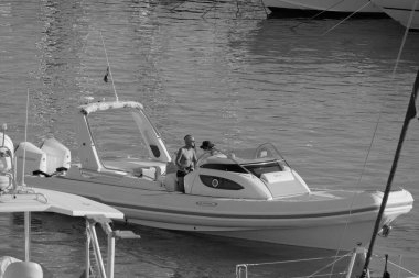 İtalya, Sicilya, Akdeniz, Marina di Ragusa (Ragusa ili); 25 Ağustos 2025, limandaki büyük lastik bir teknede köpeği olan insanlar - EDITORIAL