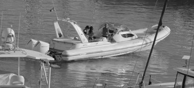 İtalya, Sicilya, Akdeniz, Marina di Ragusa (Ragusa ili); 25 Ağustos 2025, limandaki büyük lastik bir teknede köpeği olan insanlar - EDITORIAL