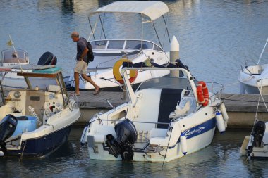 İtalya, Sicilya, Akdeniz, Marina di Ragusa (Ragusa ili); 26 Ağustos 2025, limandaki insanlar, motorlu tekneler ve lüks yatlar - EDITORIAL