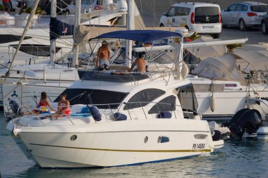 İtalya, Sicilya, Akdeniz, Marina di Ragusa (Ragusa ili); 27 Ağustos 2025, limanda lüks bir yatta insanlar - EDITORIAL