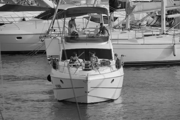 İtalya, Sicilya, Akdeniz, Marina di Ragusa (Ragusa ili); 27 Ağustos 2025, limanda lüks bir yatta insanlar - EDITORIAL