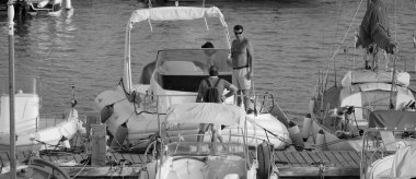 İtalya, Sicilya, Akdeniz, Marina di Ragusa (Ragusa ili); 28 Ağustos 2025, limanda insanlar ve motorlu tekneler - EDITORIAL