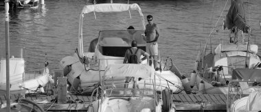 İtalya, Sicilya, Akdeniz, Marina di Ragusa (Ragusa ili); 28 Ağustos 2025, limanda insanlar ve motorlu tekneler - EDITORIAL